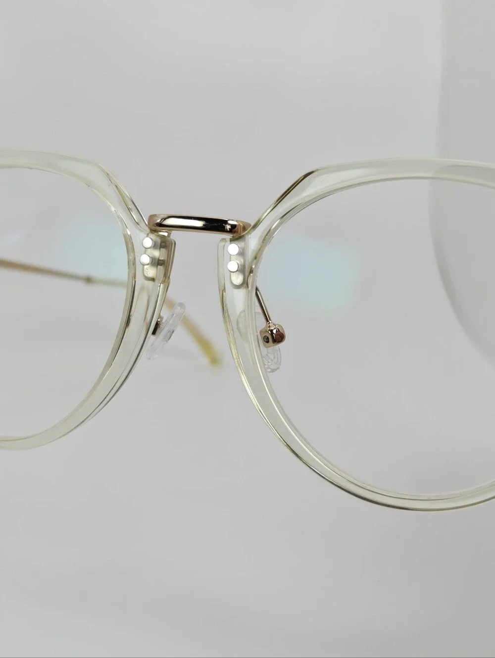 Tamara. Clear Round Frame Glasses. All Gold Accents are Metal.